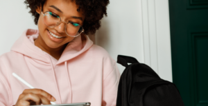 Jeune femme écrivant avec un stylet sur une tablette tactile.